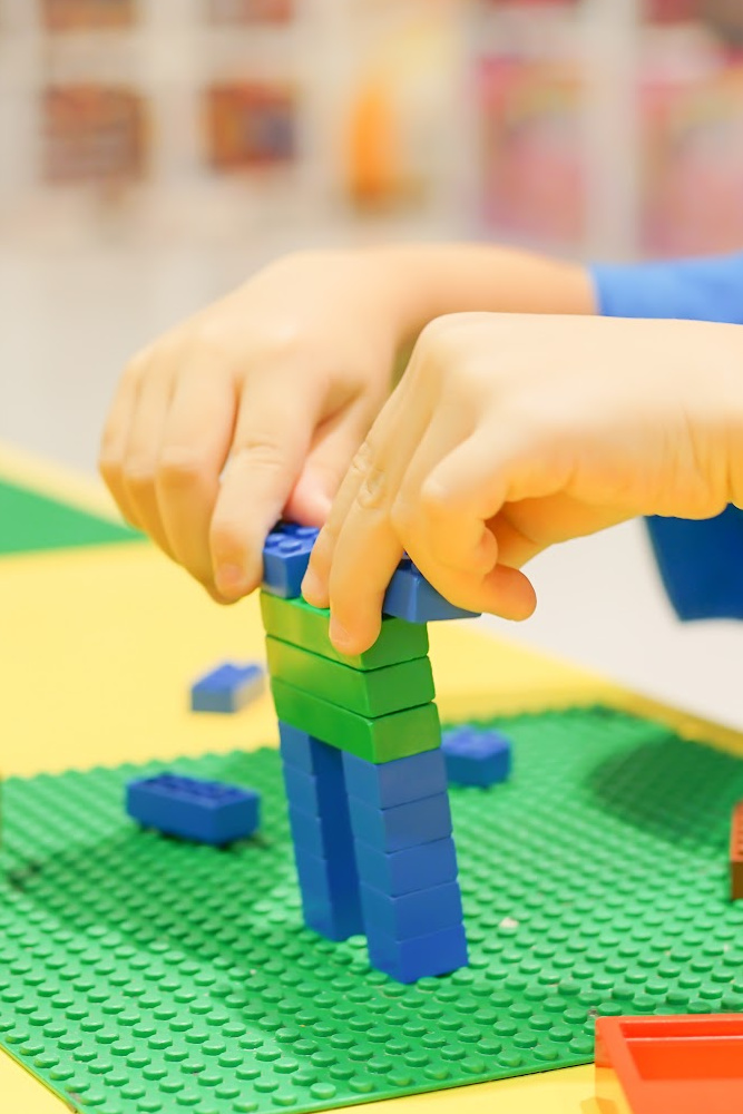 Kid playing with Legos at Kids's Club Academy Kid playing with Legos at Kids's Club Academy