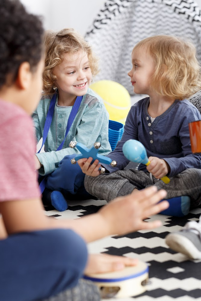 Children sitting on a rug playing with toys Children sitting on a rug playing with toys