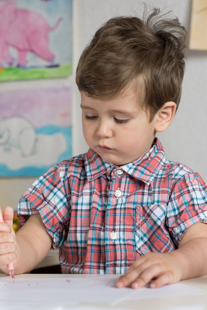 Young boy coloring on a desk Young boy coloring on a desk