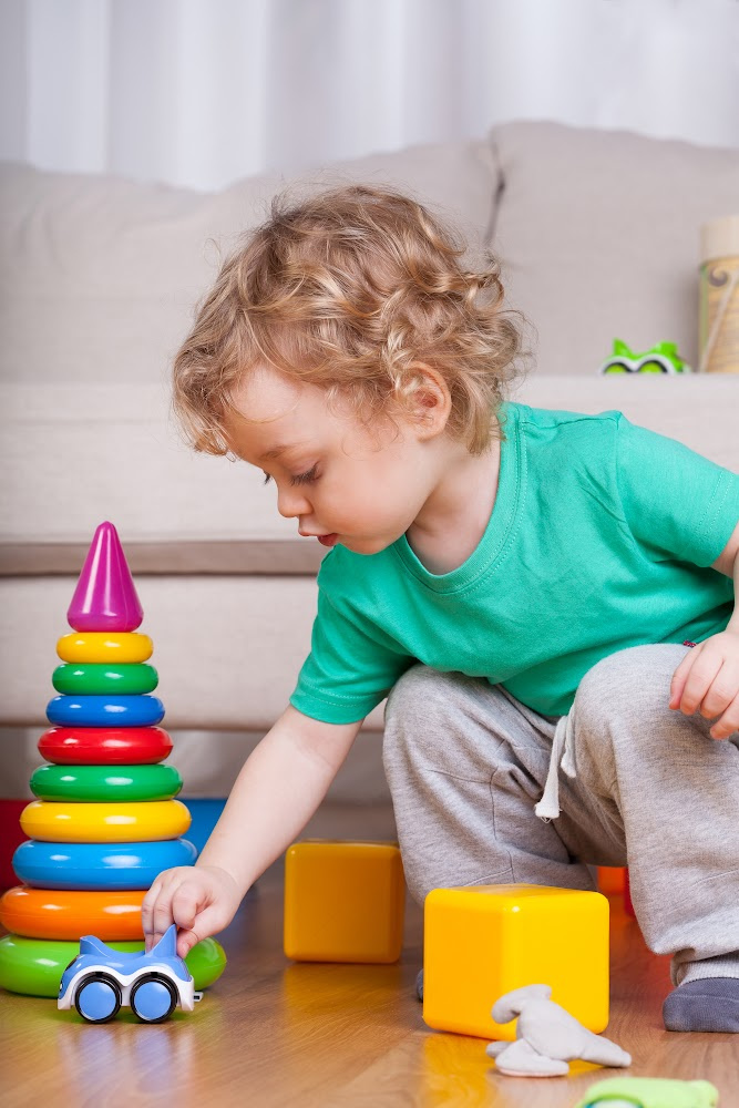 Toddler playing with toys and a car Toddler playing with toys and a car